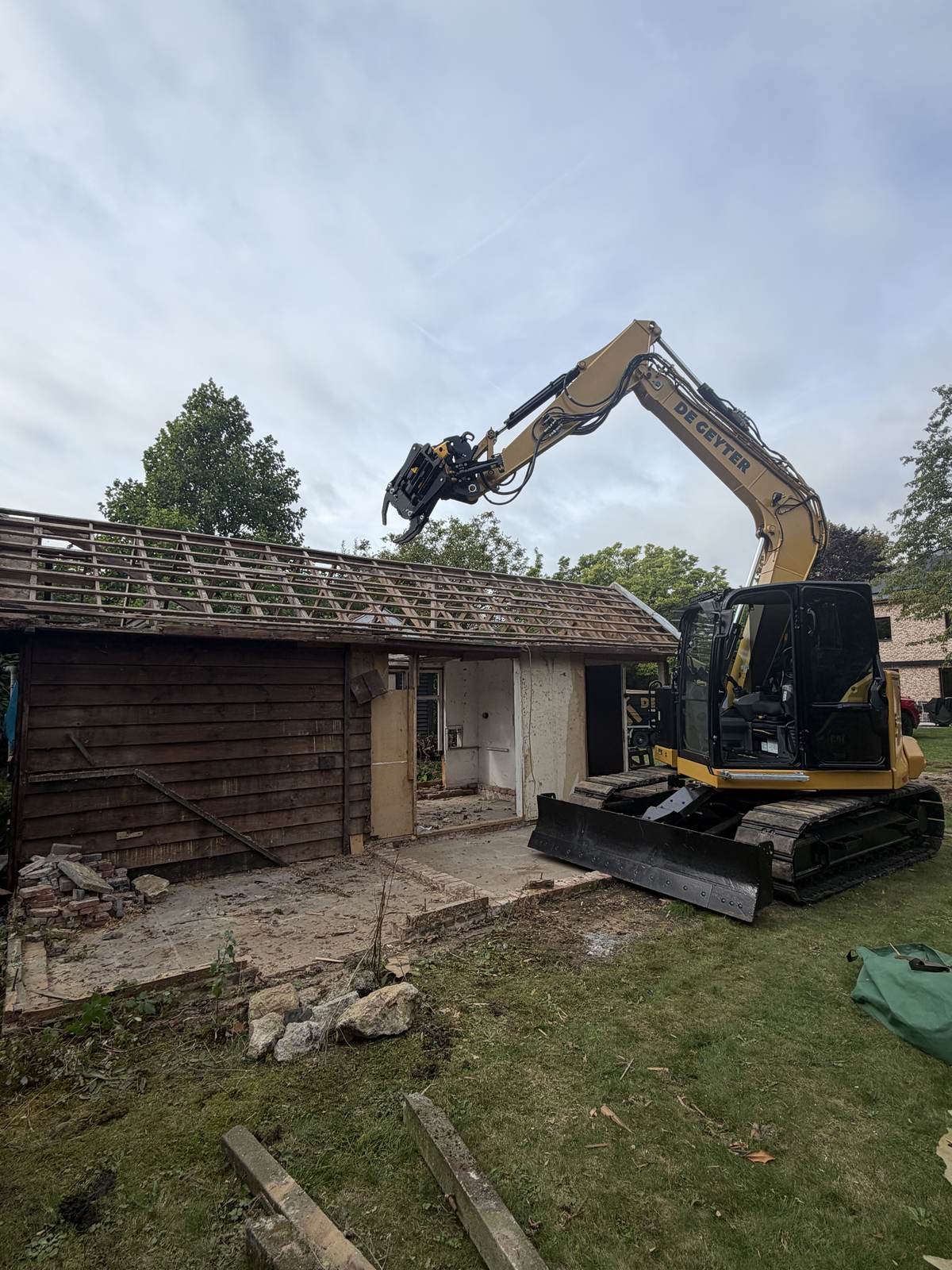 CAT 308 breekt een houten schuur af