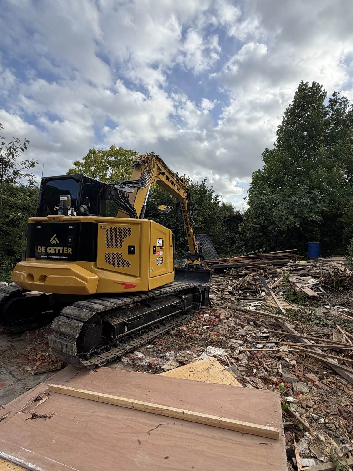 CAT 308 van De Geyter tussen afbraakpuin