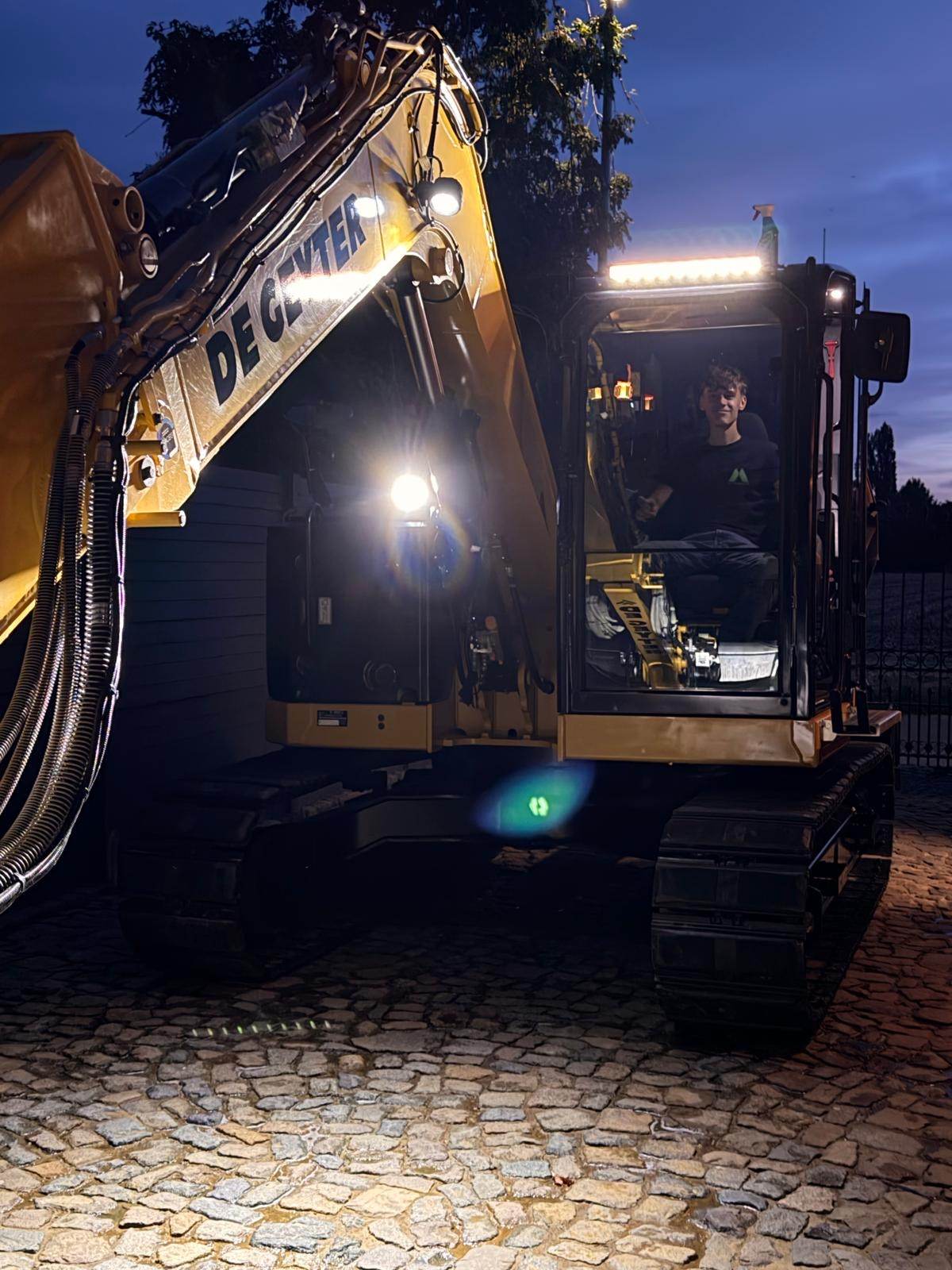 CAT 308 met werklampen, operator in de cabine